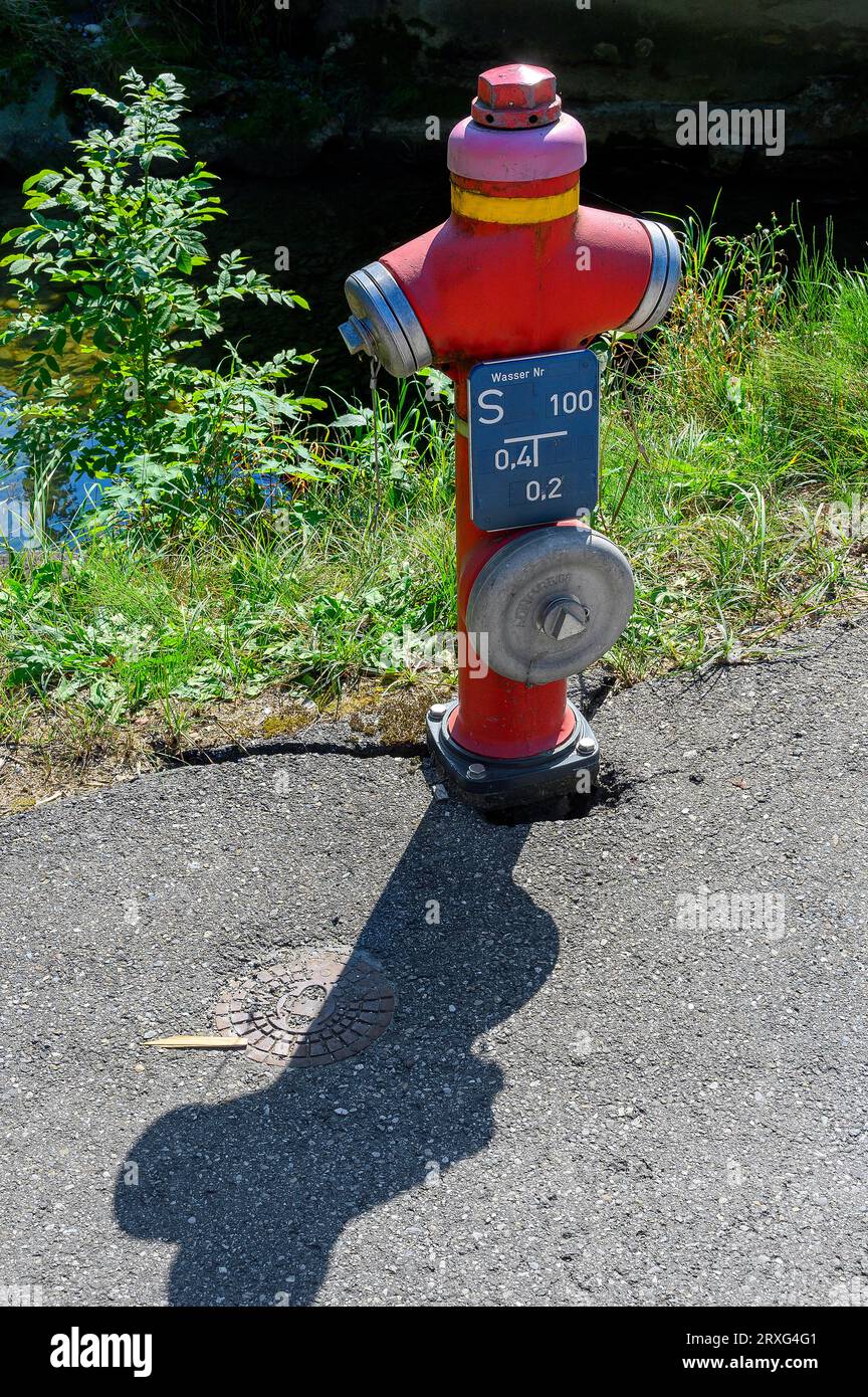 Idrante rosso con ombra, Allgaeu, Baviera, Germania Foto Stock