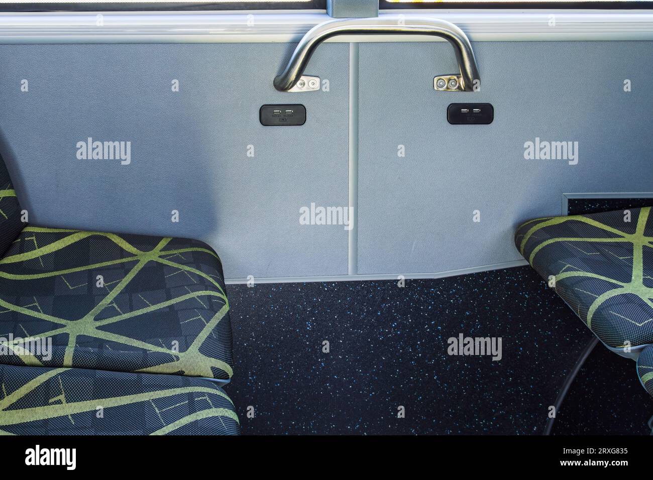 Porta di ricarica USB doppia da 5 V 2,1 A tra i sedili vuoti all'interno di un bus elettrico. Foto Stock