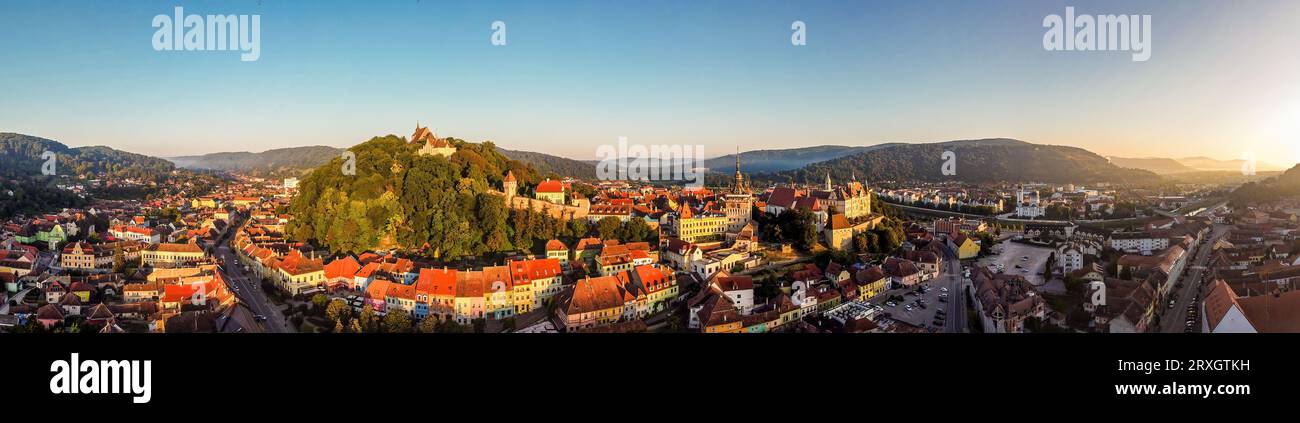 Panorama aereo all'alba della fortezza medievale e della città di Sighisoara. Foto scattata il 18 agosto 2023 a Sighisoara, Transilvania, Romani Foto Stock