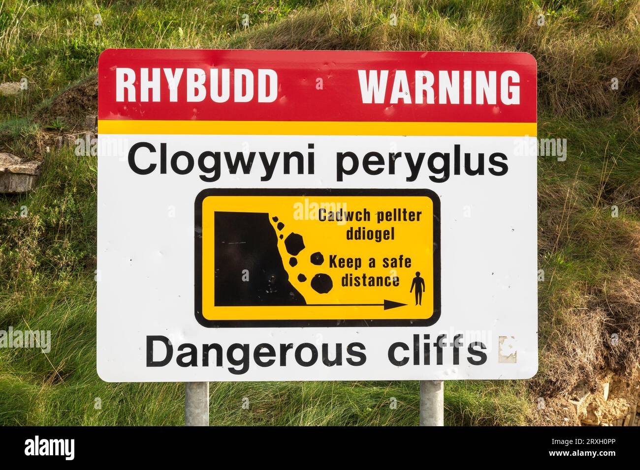 Cartello di avvertimento bilingue "Dangerous Cliffs" vicino alle scogliere di Llantwit Major Beach, Glamorgan, Galles. Foto Stock