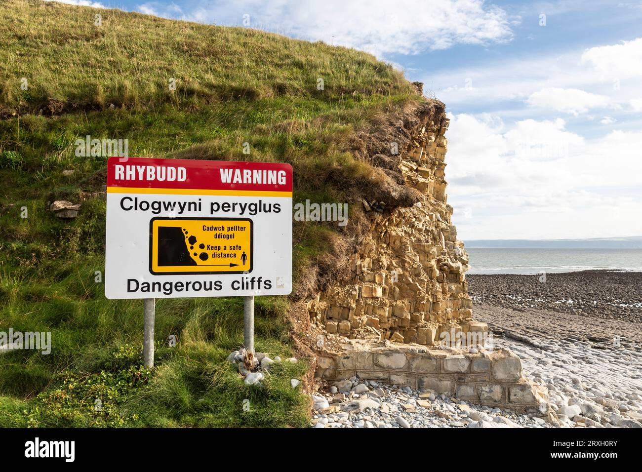 Cartello di avvertimento bilingue "Dangerous Cliffs" vicino alle scogliere di Llantwit Major Beach, Glamorgan, Galles. Foto Stock