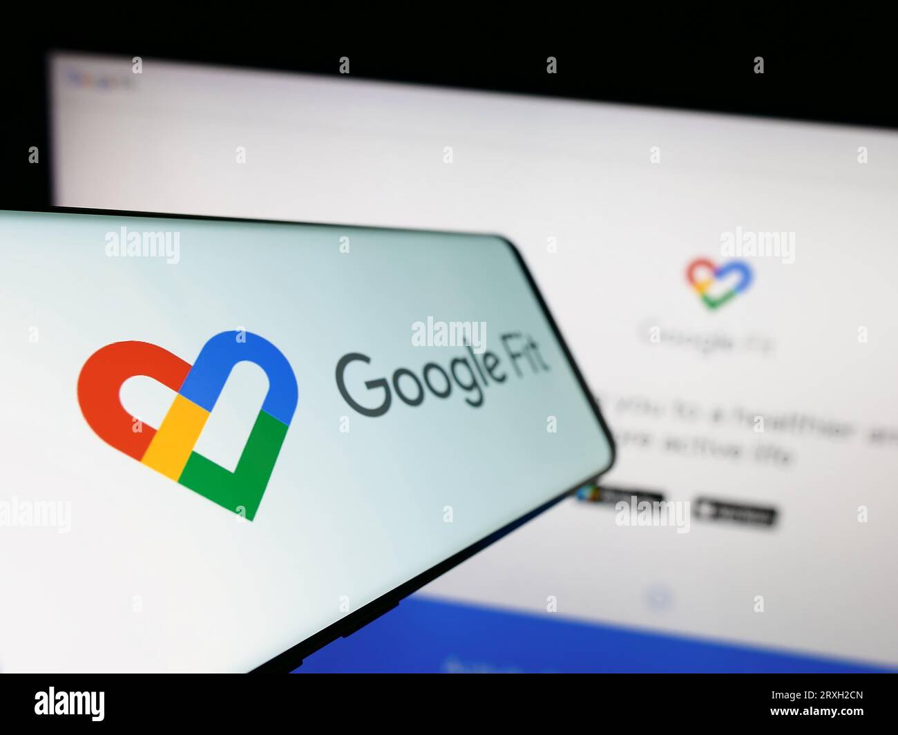 Telefono cellulare con logo del software di monitoraggio della salute Google Fit sullo schermo di fronte al sito Web dell'azienda. Mettere a fuoco sul lato sinistro del display del telefono. Foto Stock