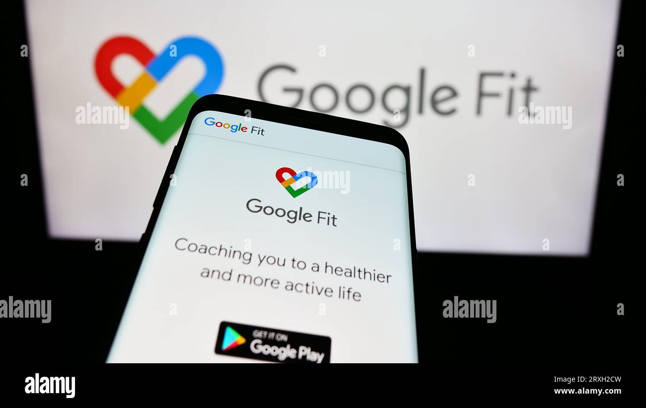 Smartphone con sito Web del software di monitoraggio della salute Google Fit sullo schermo davanti al logo aziendale. Mettere a fuoco in alto a sinistra sul display del telefono. Foto Stock