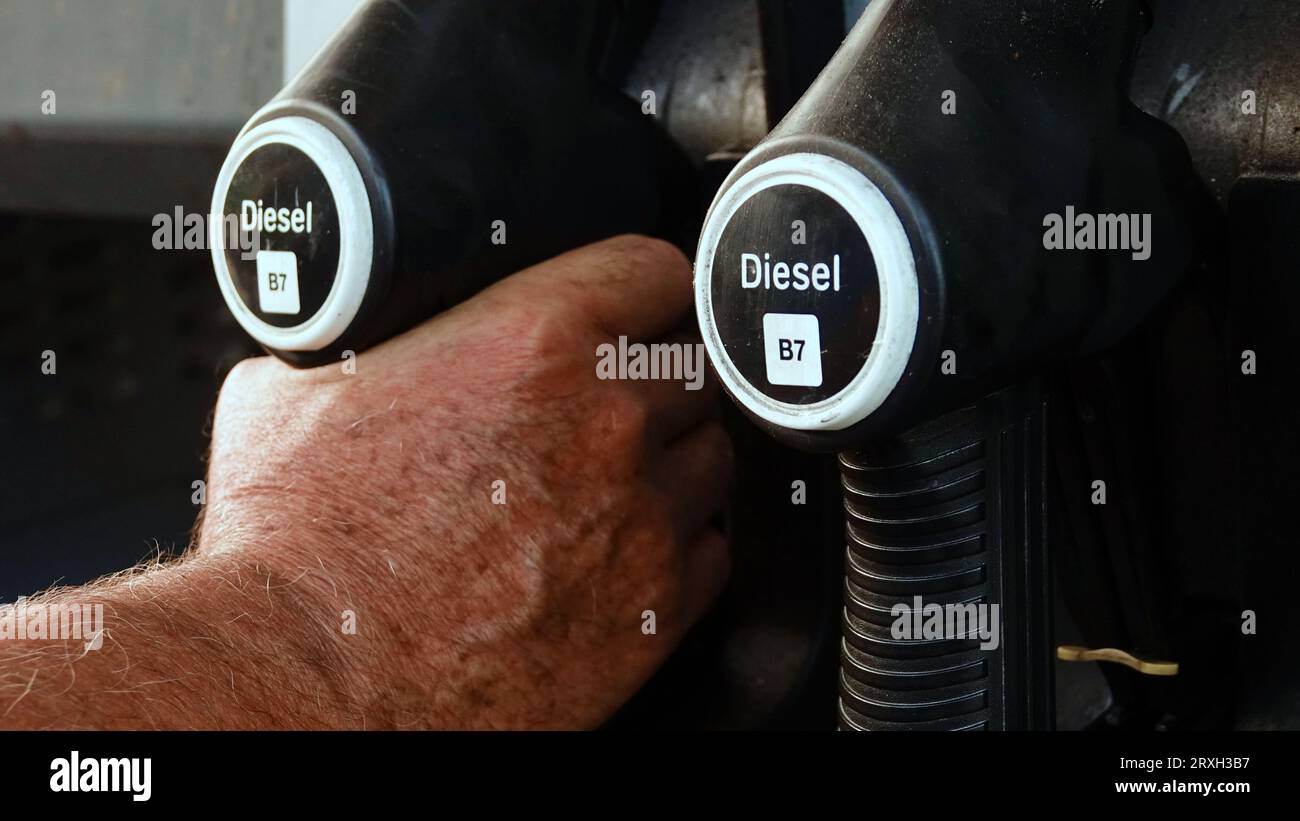 Rifornire l'auto, la mano di un uomo riempie il gasolio presso la stazione di servizio e la pompa di benzina riempie la pistola del carburante nel serbatoio dell'auto. Foto Stock