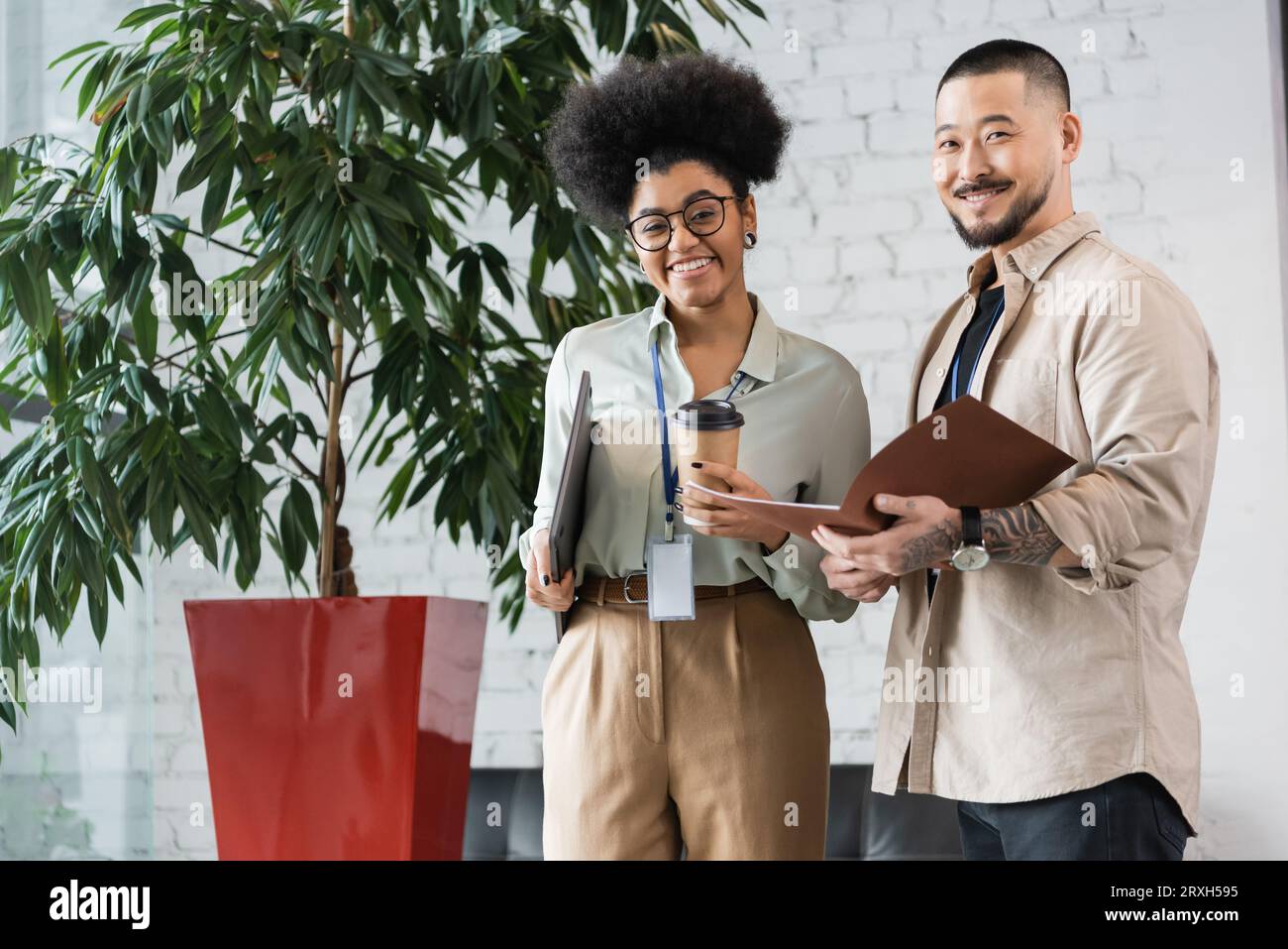 simpatici lavoratori interrazziali che guardano la macchina fotografica durante la pausa caffè, diversità aziendale Foto Stock