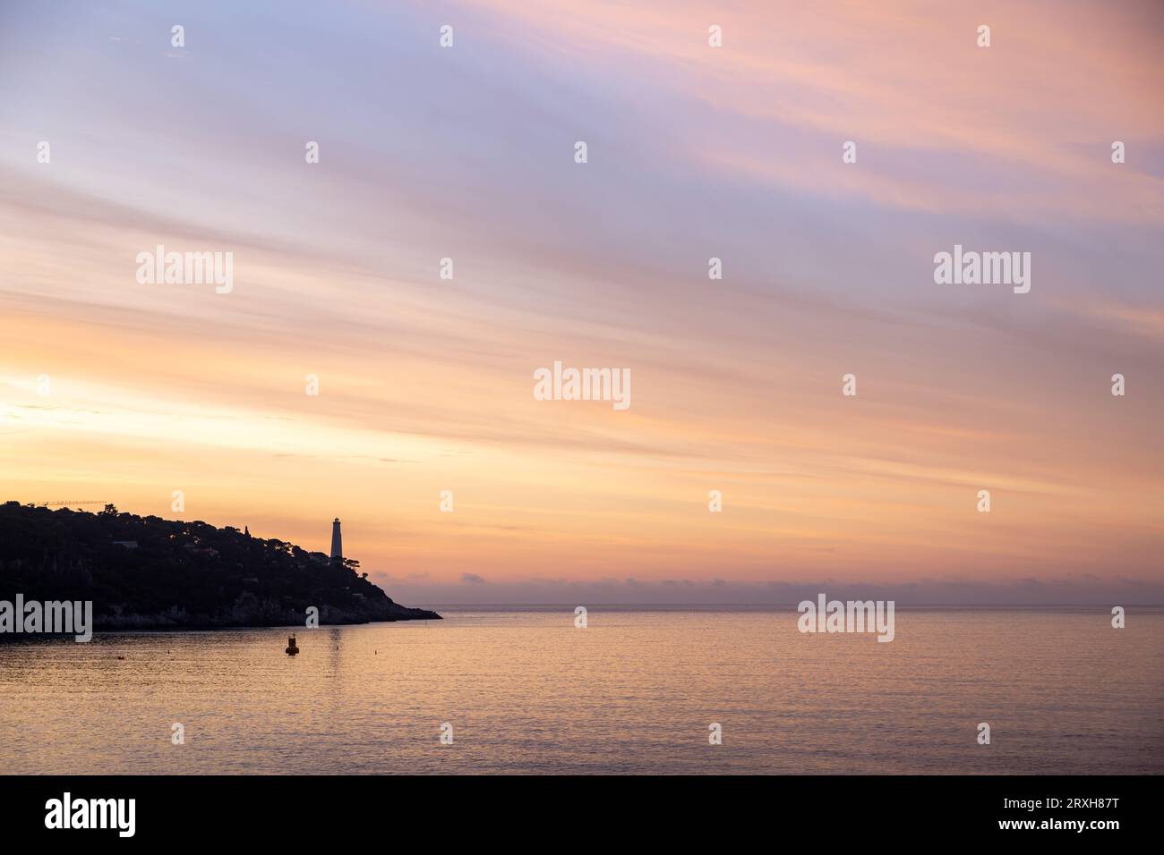 Guardando a est sul faro di Phare du Cap Ferrat e sul cielo colorato all'alba; Foto Stock
