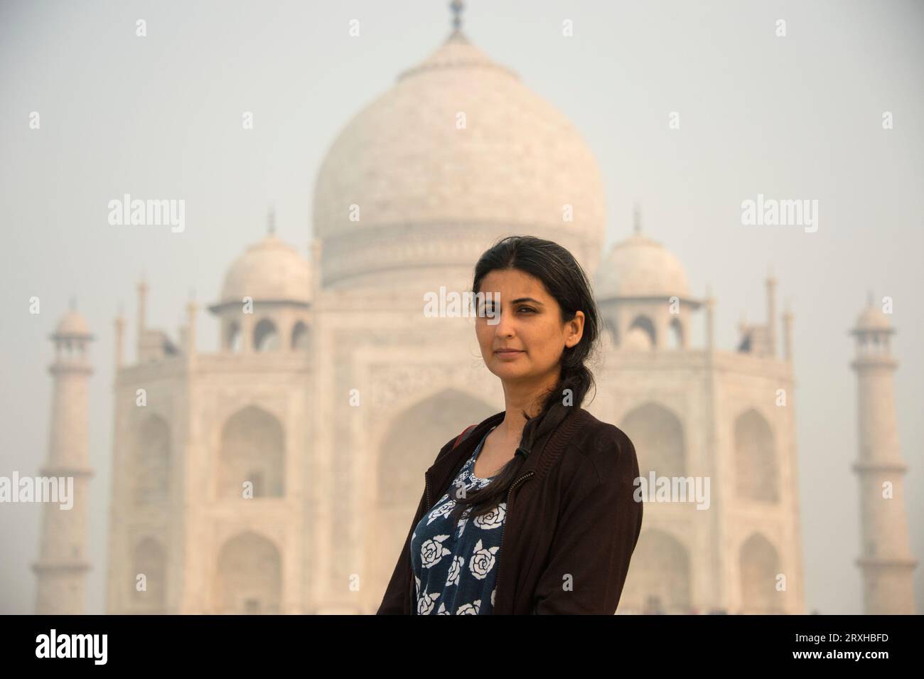 Ritratto di una giovane donna di fronte al Taj Mahal ad Agra, Uttar Pradesh, India; Agra, Uttar Pradesh, India Foto Stock