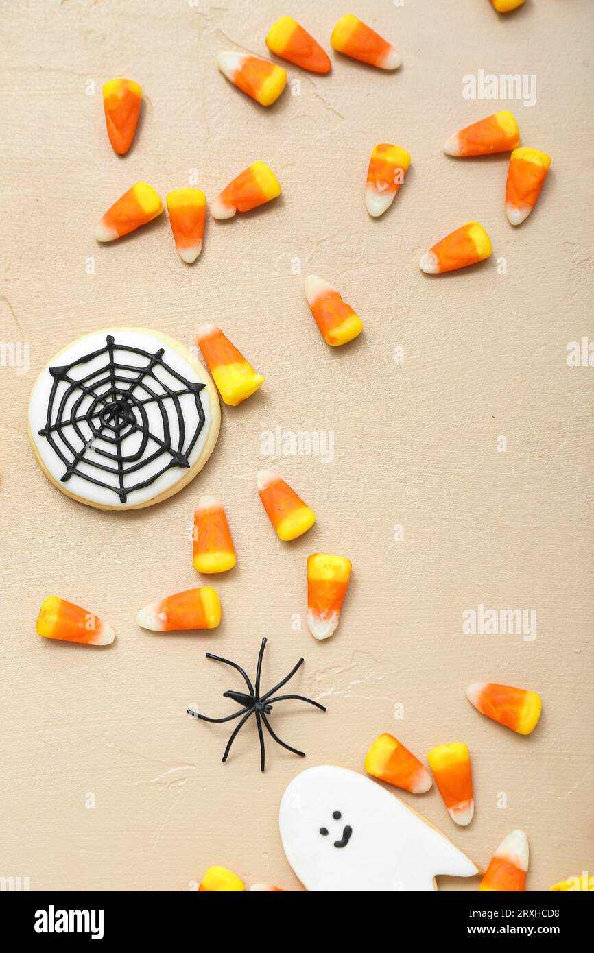 Gustosi grani di caramelle di Halloween e biscotti su sfondo beige Foto Stock