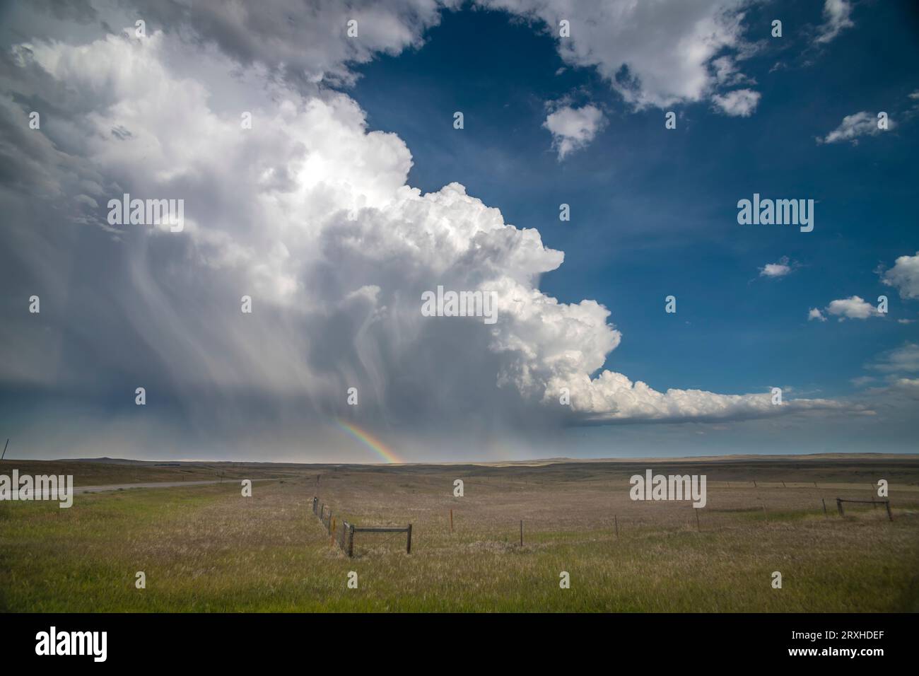 Le enormi piogge di thunderhead e la grandine nella prateria del sud-est del Wyoming offrono un meraviglioso arcobaleno per chi si trova in questo lato della tempesta Foto Stock