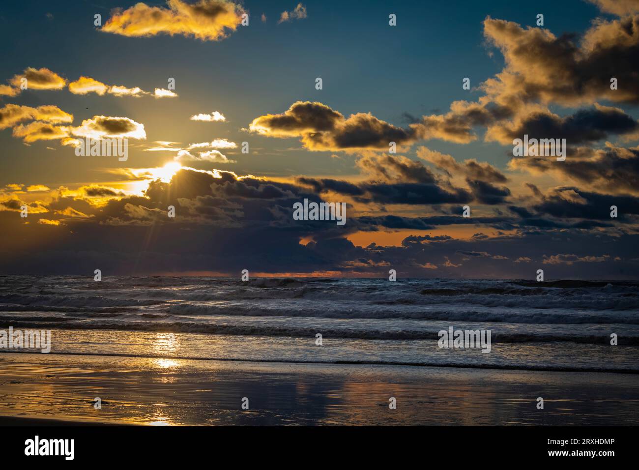 Splendido tramonto che si riflette sulla spiaggia e sul surf sulla costa di Washington; Ilwaco, Washington, Stati Uniti d'America Foto Stock
