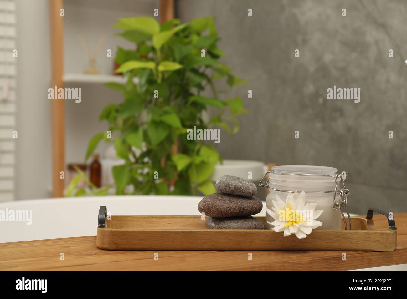 Prodotti spa e bellissimi fiori su vassoio in legno in bagno Foto Stock