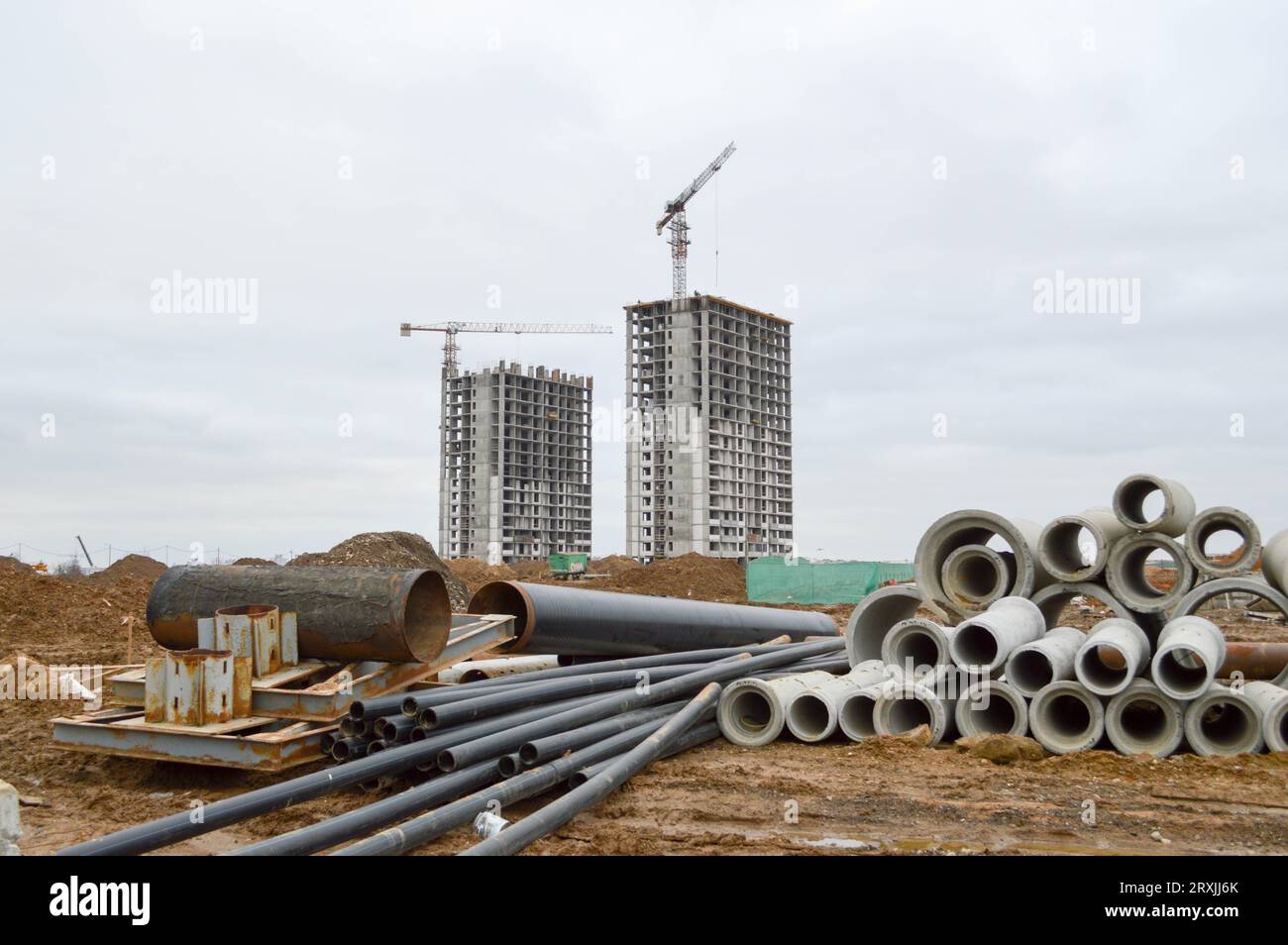 Tubi idraulici per fognature in cemento e plastica nera di grandi dimensioni per la costruzione di tubi dell'acqua o fognature in un cantiere durante il rappresentante Foto Stock