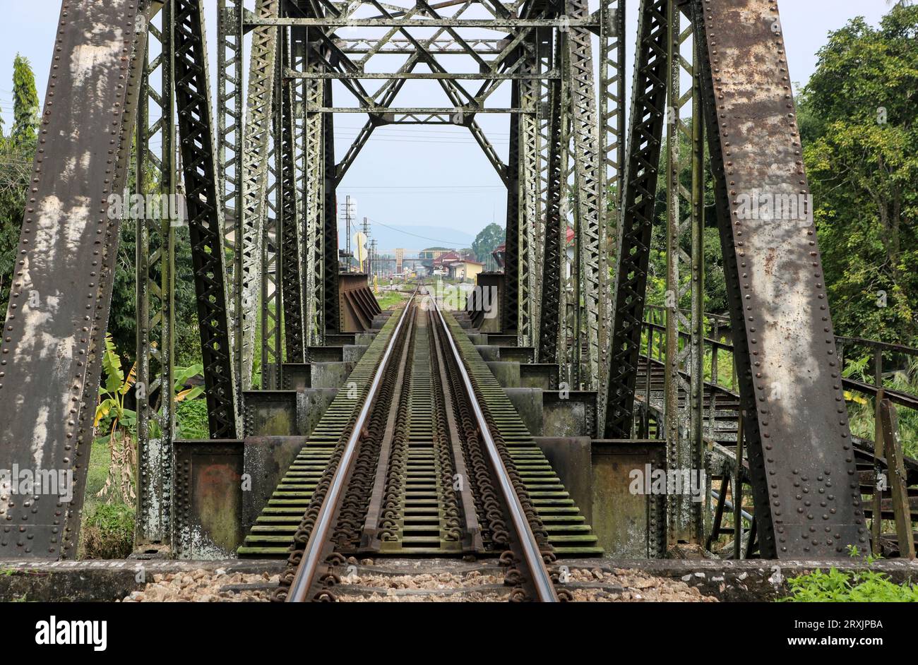 Vecchio ponte ferroviario arrugginito d'epoca sul fiume. Foto Stock