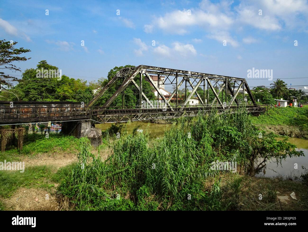 Vecchio ponte ferroviario arrugginito d'epoca sul fiume. Foto Stock