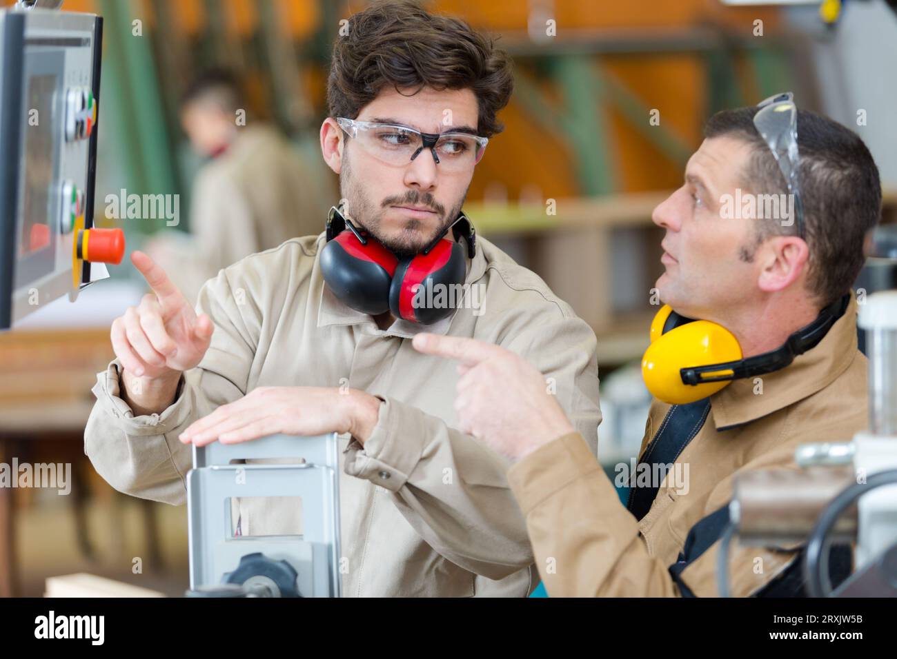 Lavoratore di funzionamento con una macchina in una fabbrica Foto Stock