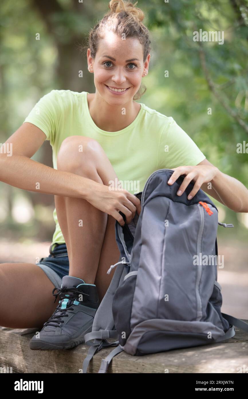 buon escursionista che guarda nello zaino Foto Stock