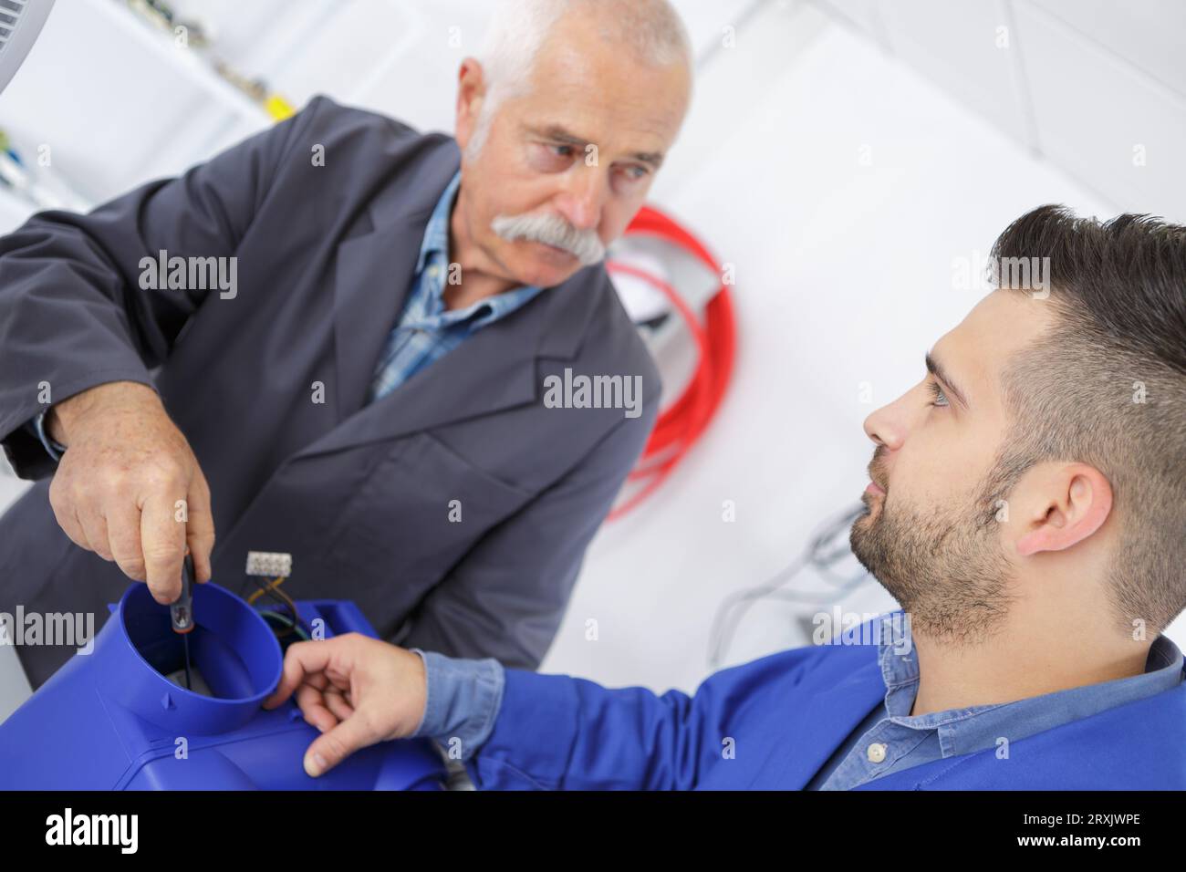 ritratto dell'apprendista che studia la scatola di ventilazione Foto Stock