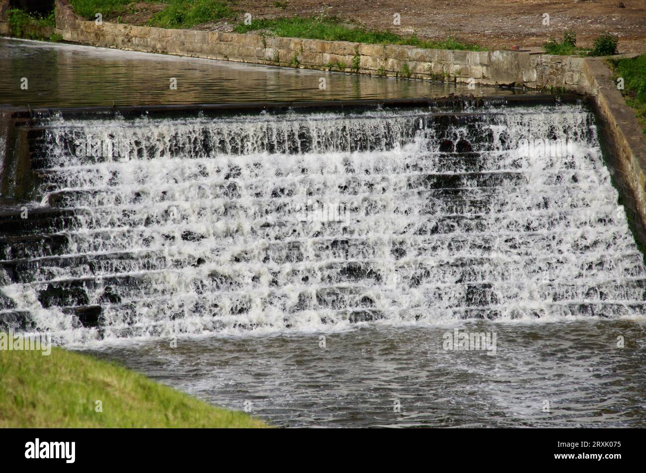 Acqua che scende lungo una diga di pietra, Yorkshire, Inghilterra, Regno Unito. Foto Stock