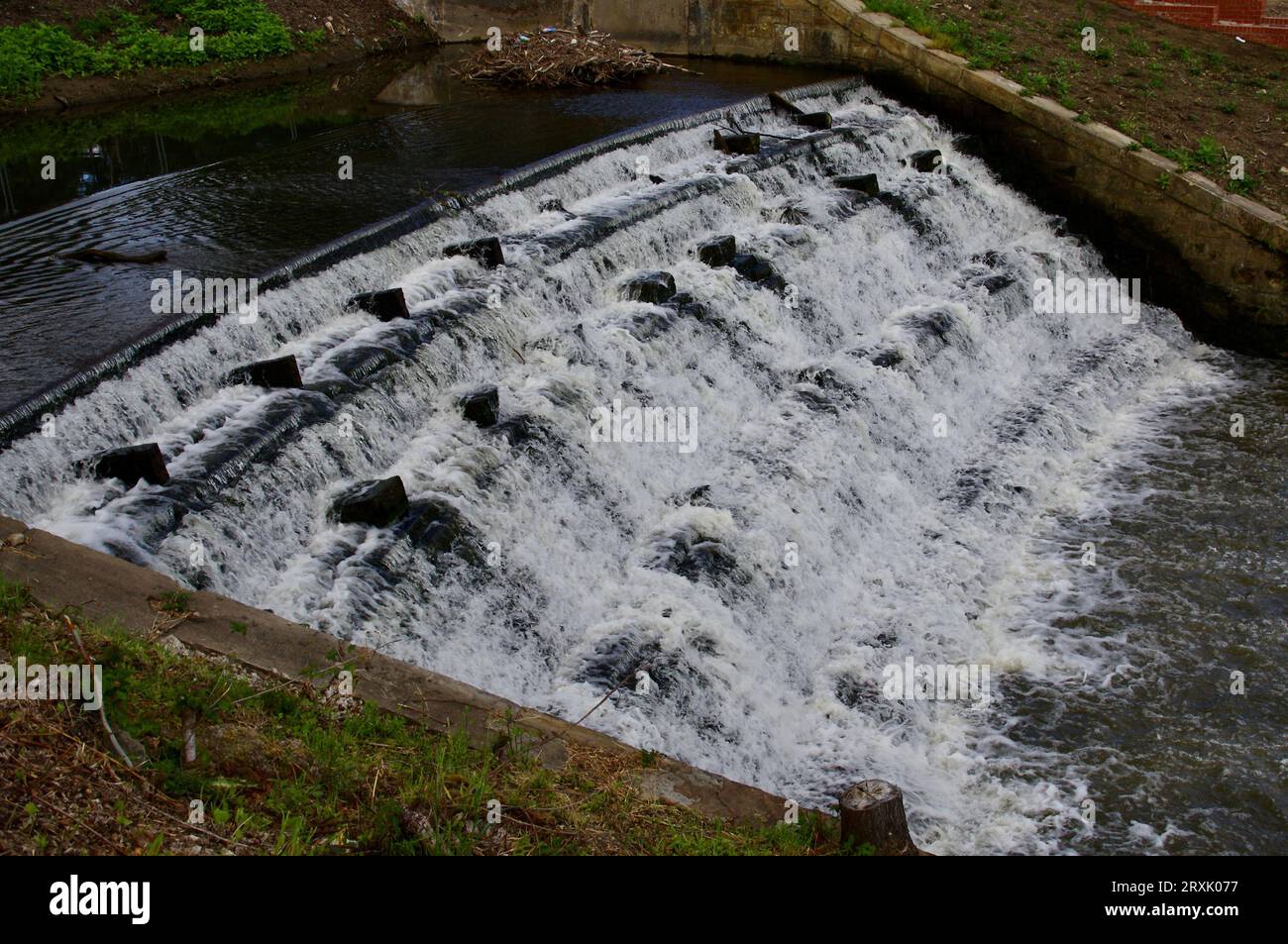Acqua che scende lungo una diga di pietra, Yorkshire, Inghilterra, Regno Unito. Foto Stock