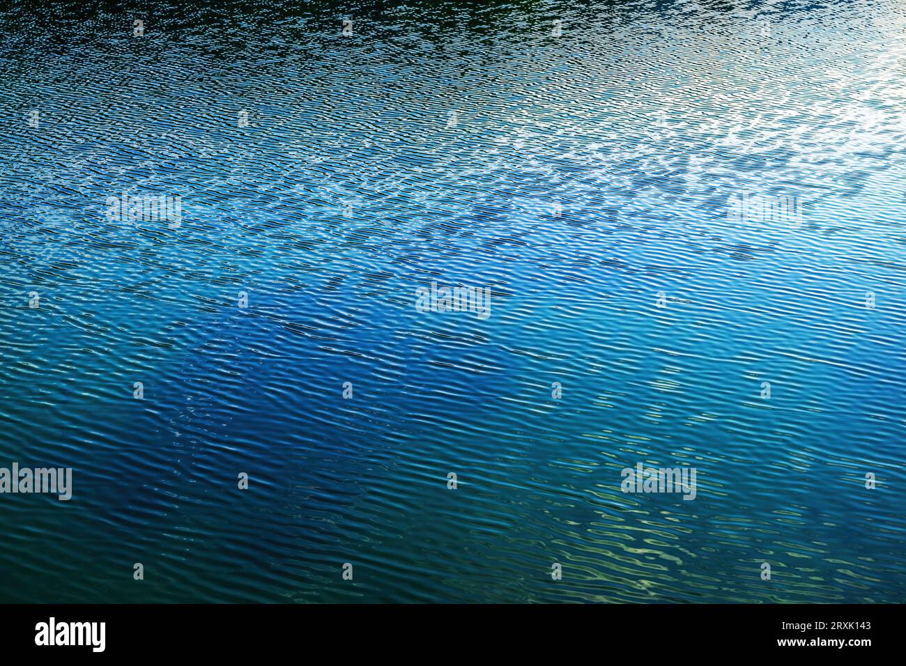 Ondulazioni sulla superficie d'acqua del lago glaciale sloveno Bohhinj create dalla brezza leggera e da un paesaggio sereno Foto Stock