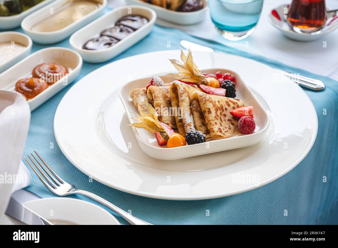 Crepes dolci con frutta di bosco al tavolo della colazione in un raffinato ristorante Foto Stock