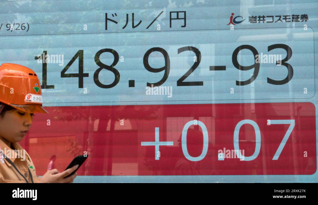 (230926) -- TOKYO, 26 settembre 2023 (Xinhua) -- Una donna passa davanti a un Consiglio mostrando il tasso di cambio a Tokyo, Giappone, 26 settembre 2023. Lo yen giapponese è sceso brevemente a 148,46 contro il dollaro statunitense qui lunedì, segnando il suo livello più basso dal novembre 2022, quando le politiche monetarie divergono tra il Giappone e gli Stati Uniti. (Xinhua/Zhang Xiaoyu) Foto Stock