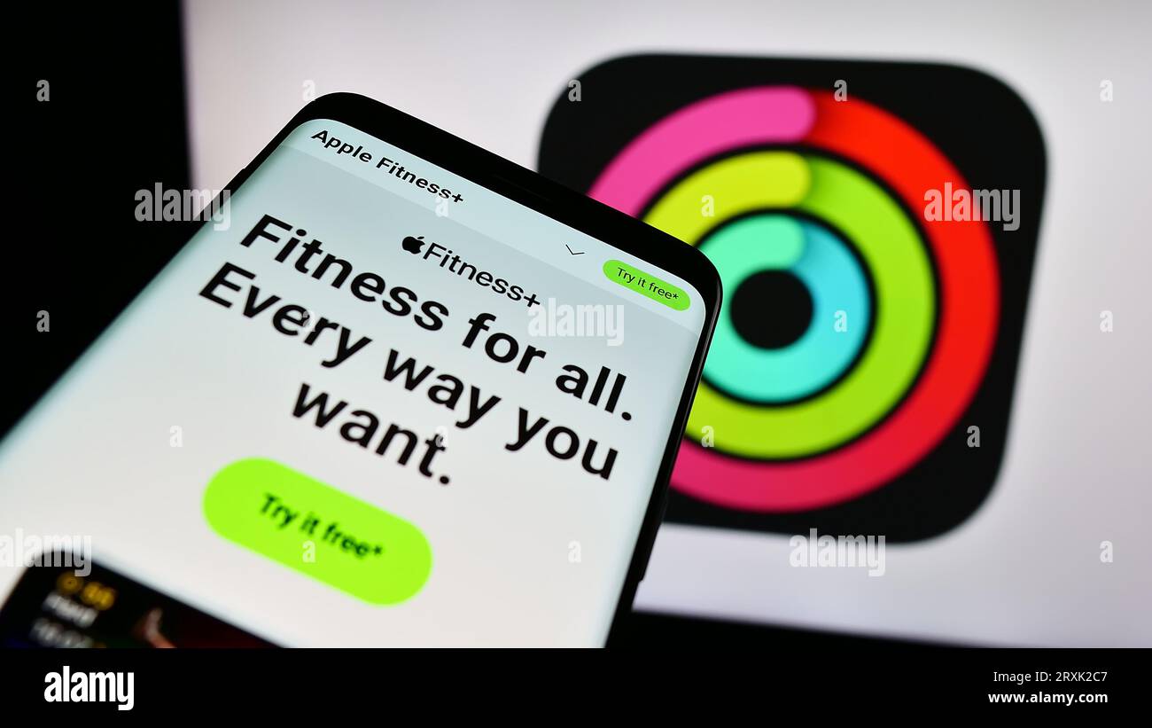 Smartphone con sito Web dell'app di monitoraggio degli esercizi Apple fitness sullo schermo davanti al logo aziendale. Mettere a fuoco in alto a sinistra sul display del telefono. Foto Stock