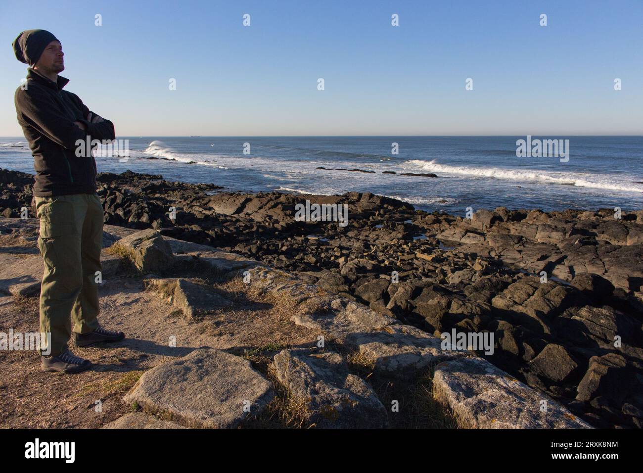 Turista in piedi sulla costa dell'oceano Atlantico. Pellegrino sul Camino de Santiago, Portogallo. Sfondo panoramico del mare. Foto Stock