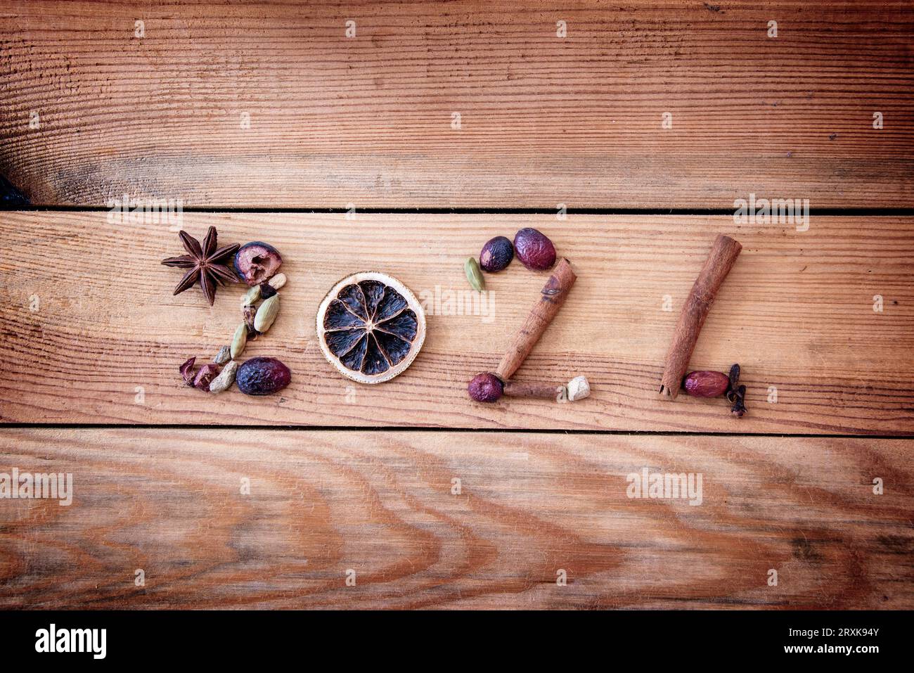 2024 scritto con spezie natalizie e frutta secca su fondo di legno, biglietto d'auguri di Capodanno Foto Stock