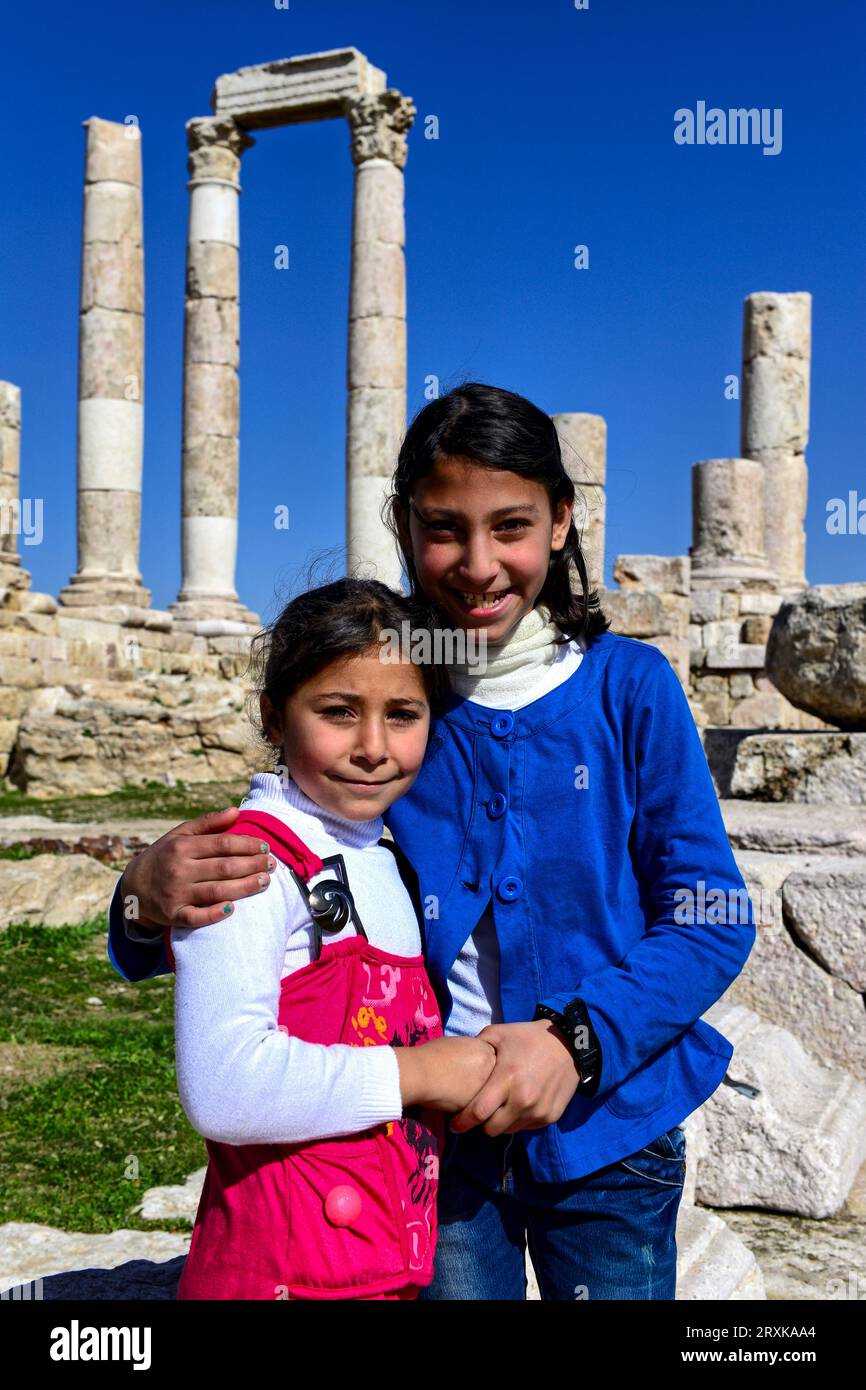 Carine ragazze locali hanno chiesto di posare per una foto al Tempio di Ercole, un tempio romano del II secolo ad Amman, Giordania, Foto Stock