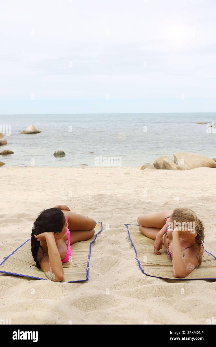 Le giovani donne a prendere il sole sulla spiaggia Foto Stock