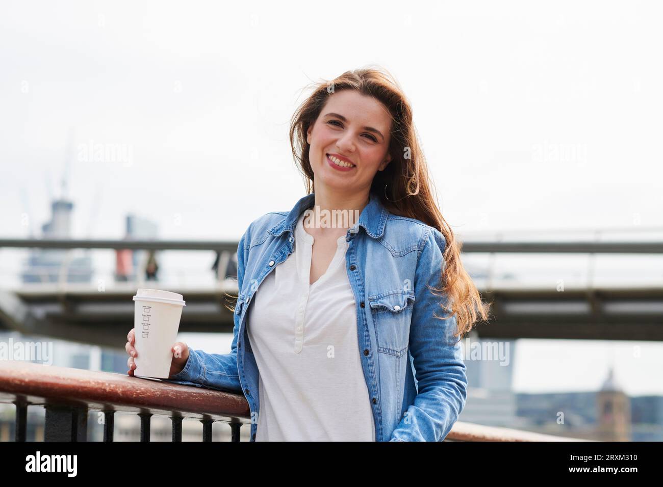 Sorridente metà donna adulta azienda caffè Foto Stock