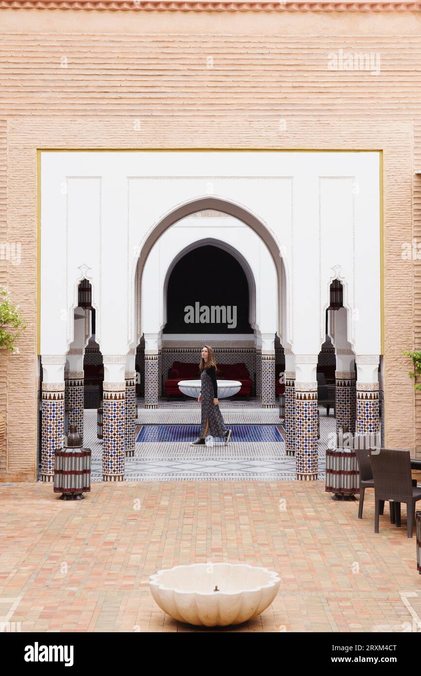 Donna che cammina nel cortile arabo Foto Stock
