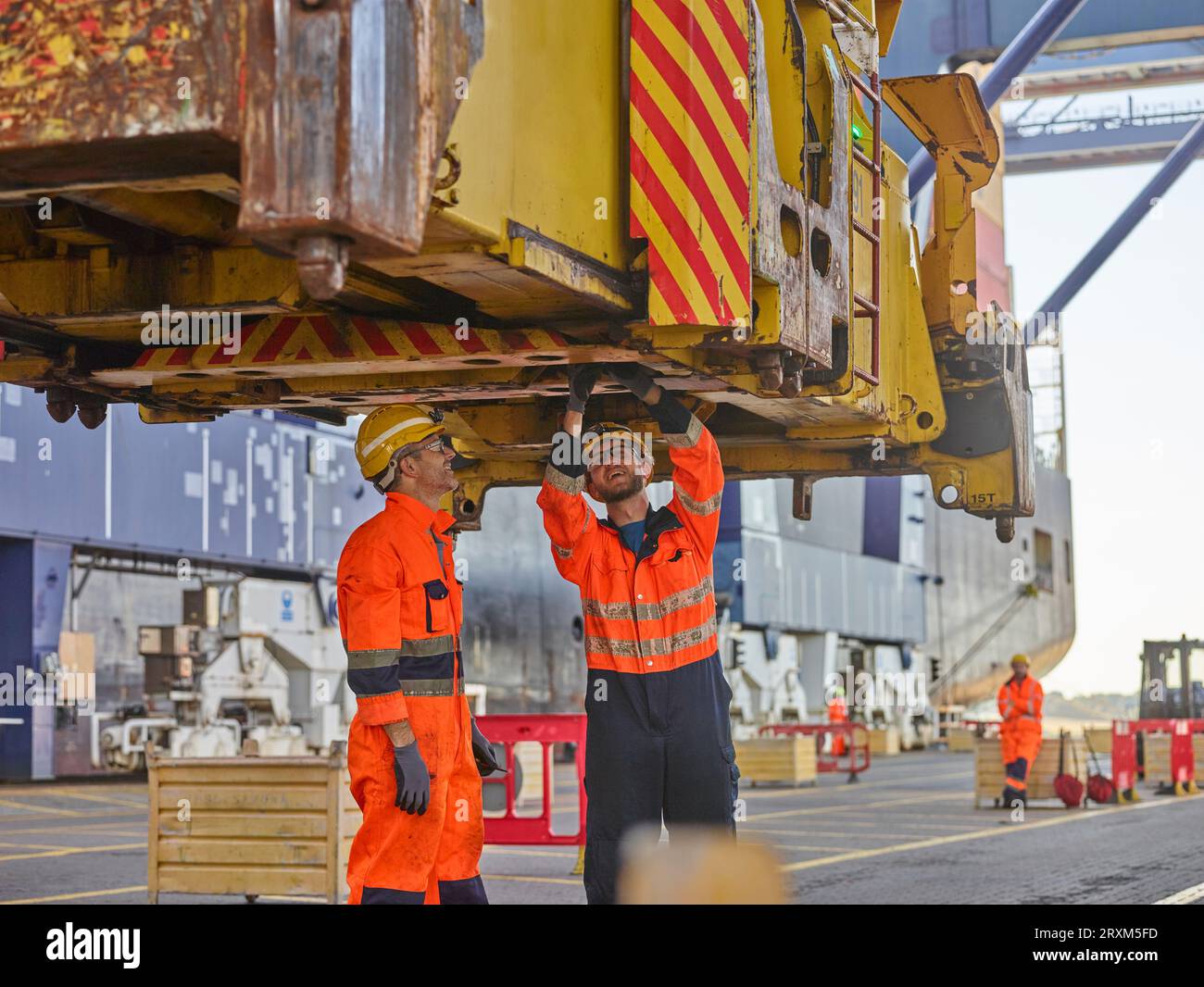 I lavoratori portuali ispezione meccanica a molletta della gru Foto Stock