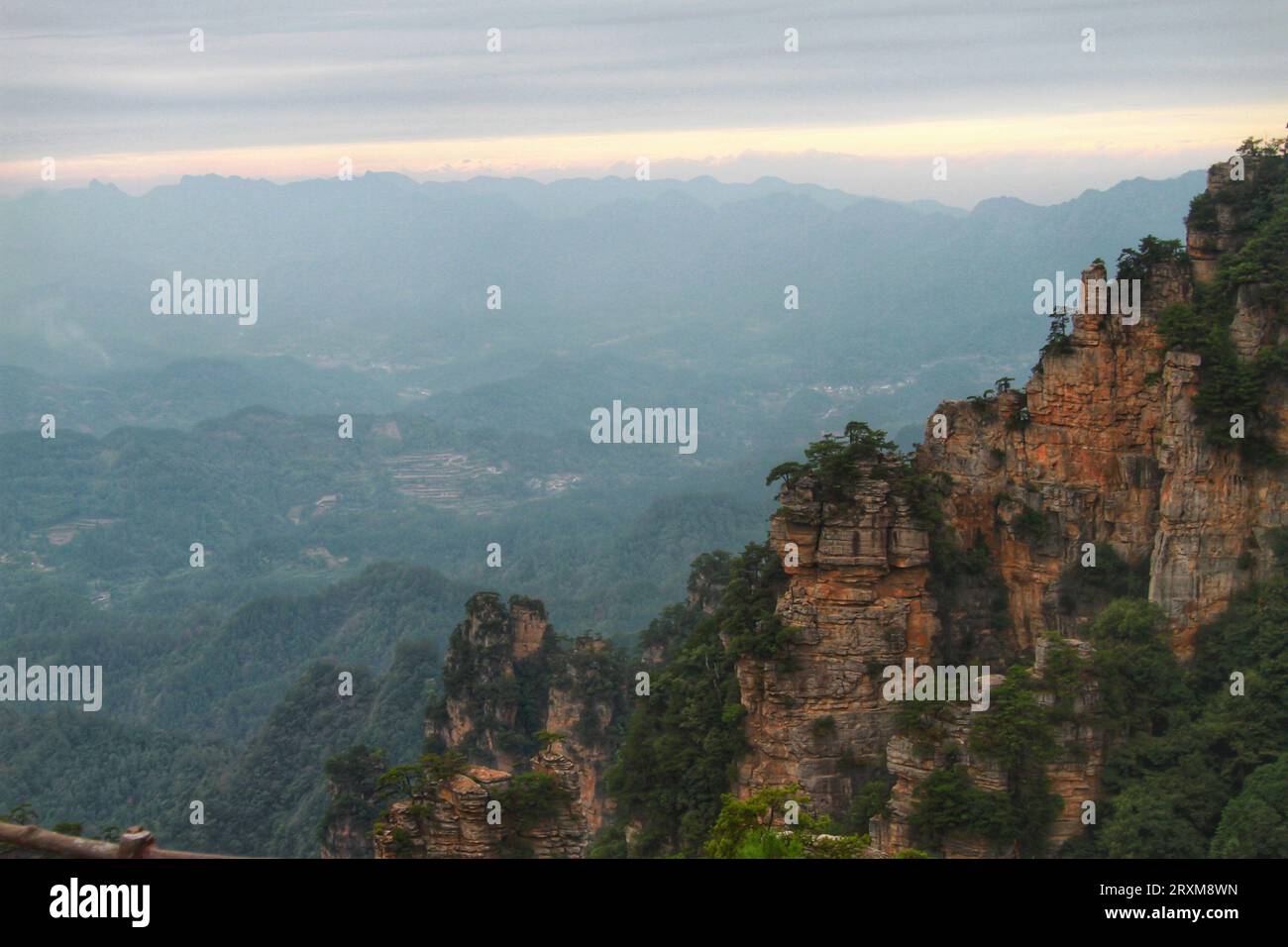 Scopri la serenità con i tappeti verdi in erba, le maestose e lunghe montagne sotto la distesa del cielo blu mozzafiato della Cina. Foto Stock