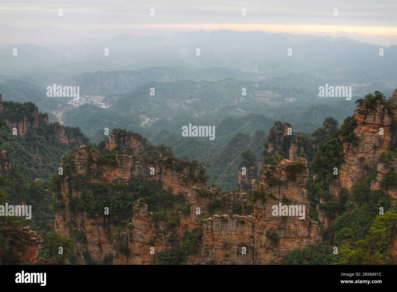 Scopri la serenità con i tappeti verdi in erba, le maestose e lunghe montagne sotto la distesa del cielo blu mozzafiato della Cina. Foto Stock