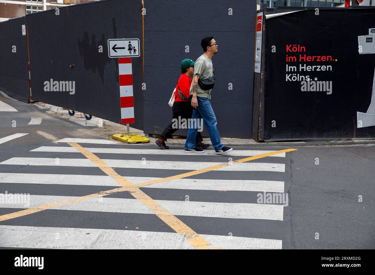Passeggiata a piedi e recinzione nei cantieri vicino alla cattedrale, Colonia, Germania. Zebrastreifen und Baustellenzaun nahe Dom, Koeln, Deutschland. Foto Stock