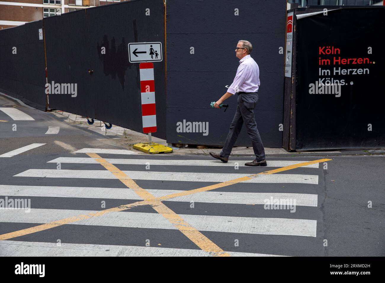 Passeggiata a piedi e recinzione nei cantieri vicino alla cattedrale, Colonia, Germania. Zebrastreifen und Baustellenzaun nahe Dom, Koeln, Deutschland. Foto Stock