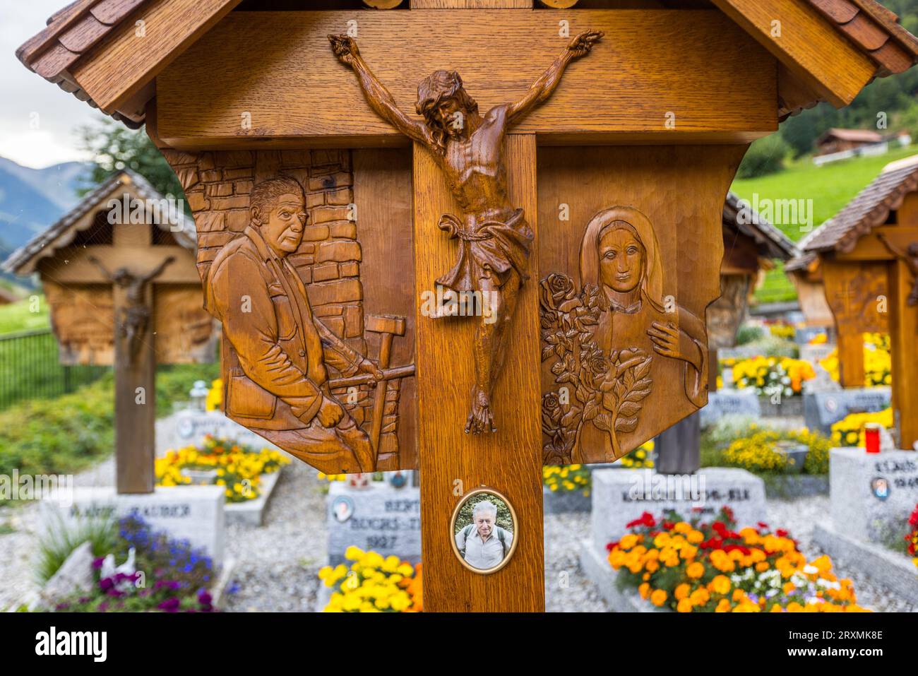 Nel cimitero dietro la chiesa di S.. Stefano in Jaun, tutte le singole tombe hanno una croce di legno intagliata con una figura di Cristo e sculture che rappresentano la professione o l'hobby del defunto. Jaun, Svizzera Foto Stock