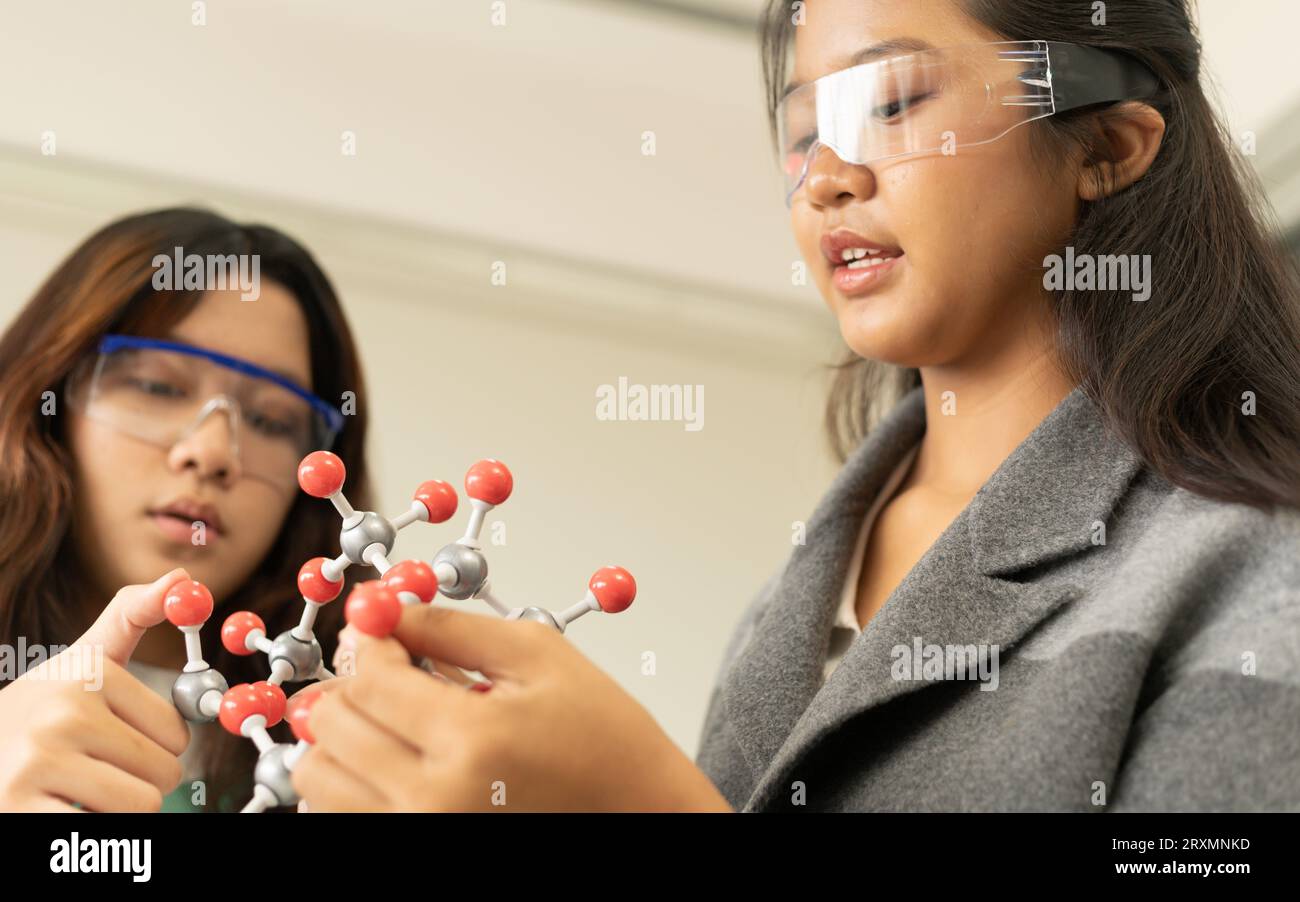 Concetto di formazione STEM. Bambini asiatici in ricerca di laboratorio un esame sperimentale con modello molecolare. Il nuovo sistema educativo in classe includina Foto Stock