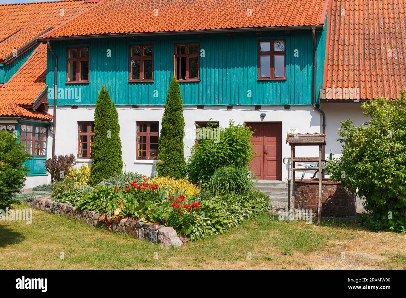 Casa rurale colorata con tetto rosso nella campagna lithiana Foto Stock