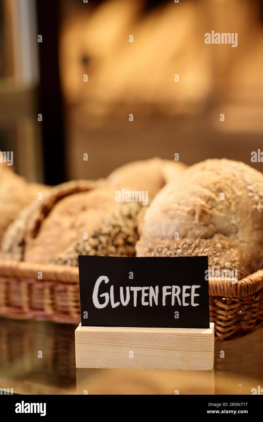 Primo piano verticale del pane fresco nel panificio artigianale con cartello senza glutine, spazio per la copia Foto Stock