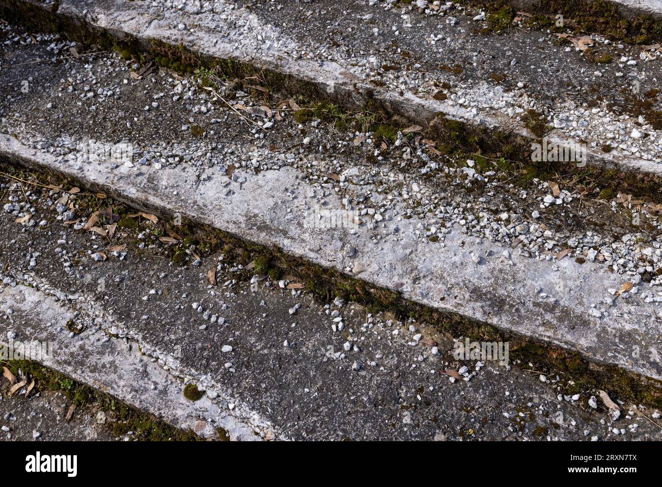 una vecchia scala in cemento rovinato e pietra nel parco, i dettagli delle vecchie parti della scala di cui sono danneggiati o distrutti Foto Stock
