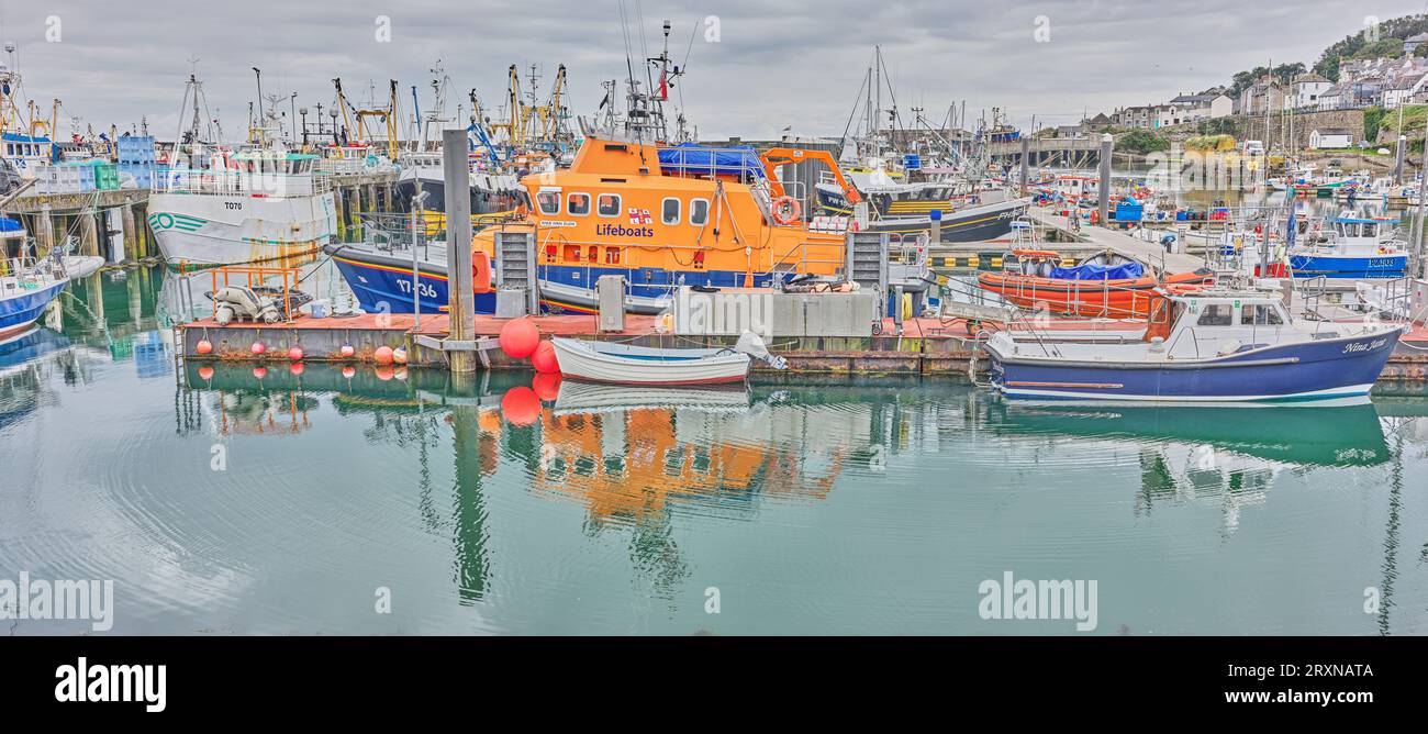 Barche, inclusa una scialuppa di salvataggio, ormeggiate nel porto di pescatori di Newlyn, Cornovaglia, Inghilterra. Foto Stock