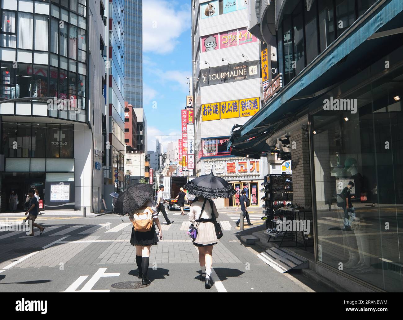 Due ragazze giapponesi attente alla moda camminano lungo il marciapiede di Ikebukuro, Tokyo, Giappone Foto Stock