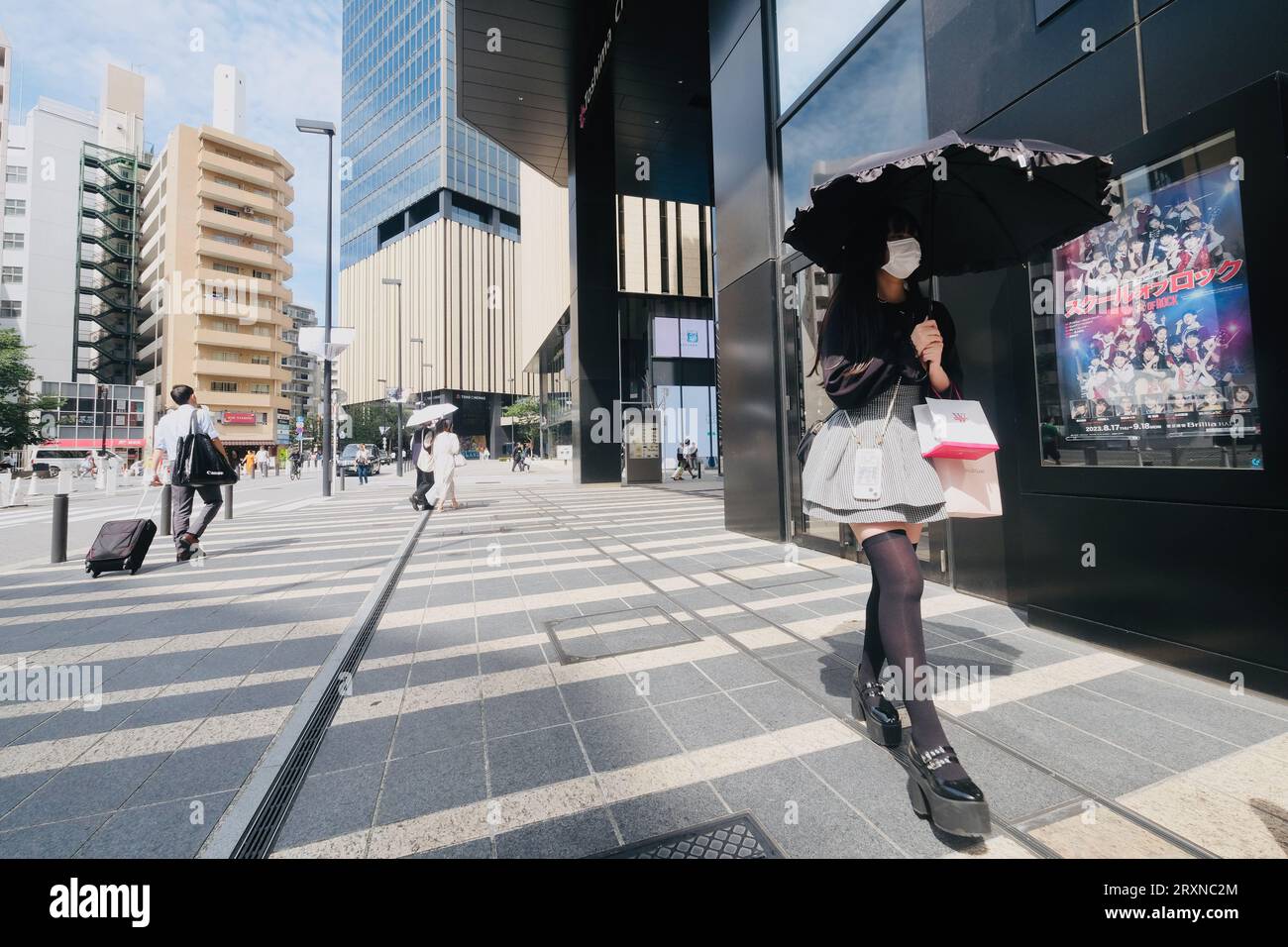 Una ragazza giapponese attenta alla moda cammina lungo il marciapiede di Ikebukuro, Tokyo, Giappone Foto Stock