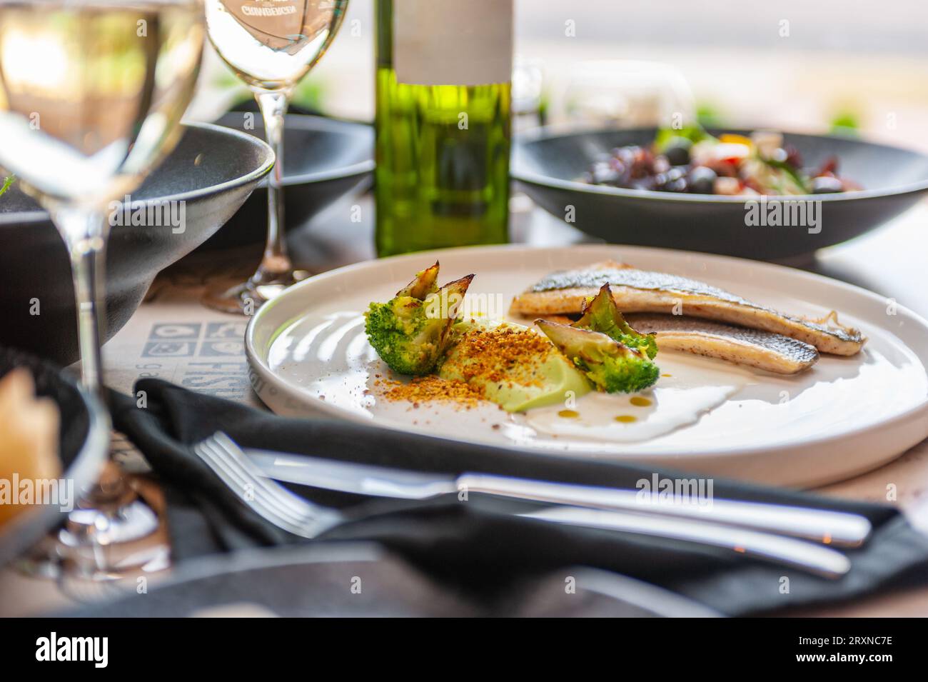 Dorado o filetto di spigola in salsa di panna con broccoli su un piatto bianco. Foto di alta qualità Foto Stock