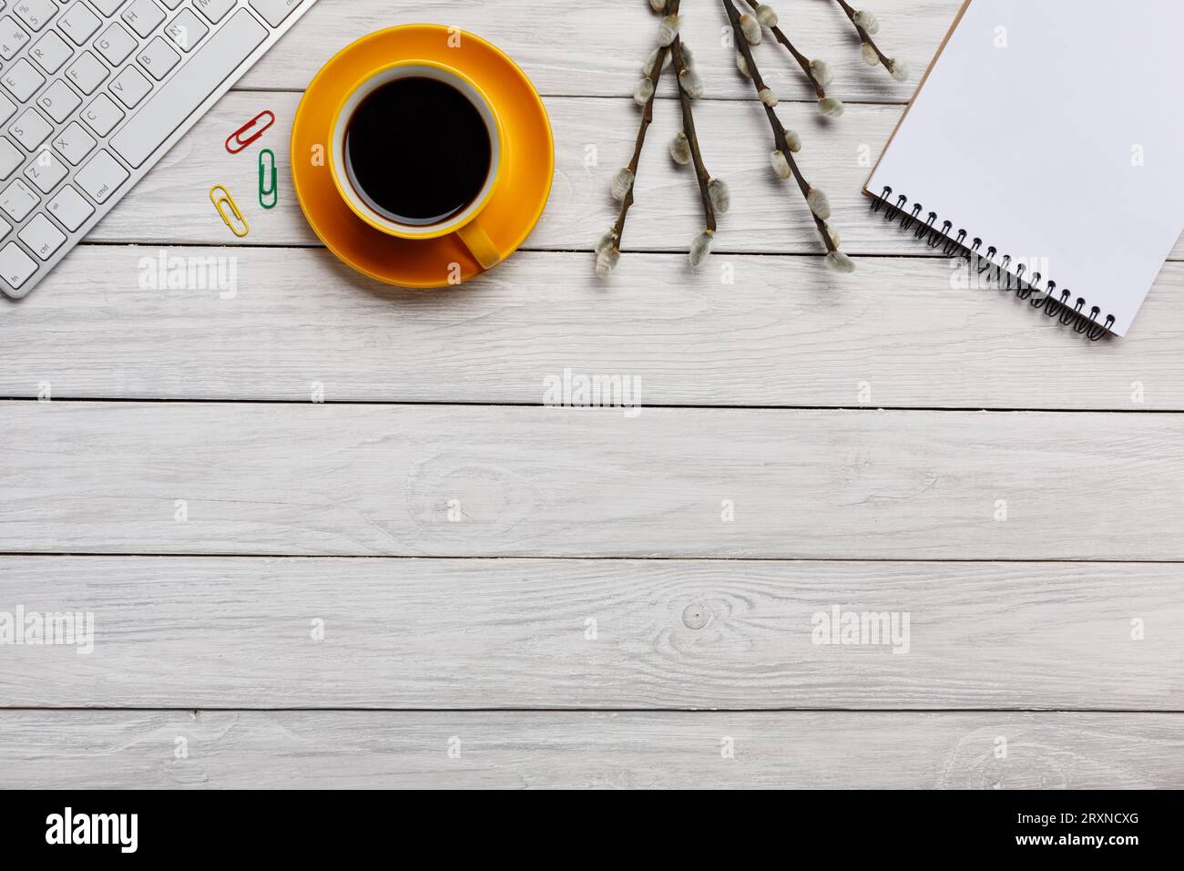 Carta da scrivania bianca gialla tazza di caffè, gomma per notebook, tastiera, rilegatura per mouse, fermaglio a forma di fiore, molla salice Foto Stock