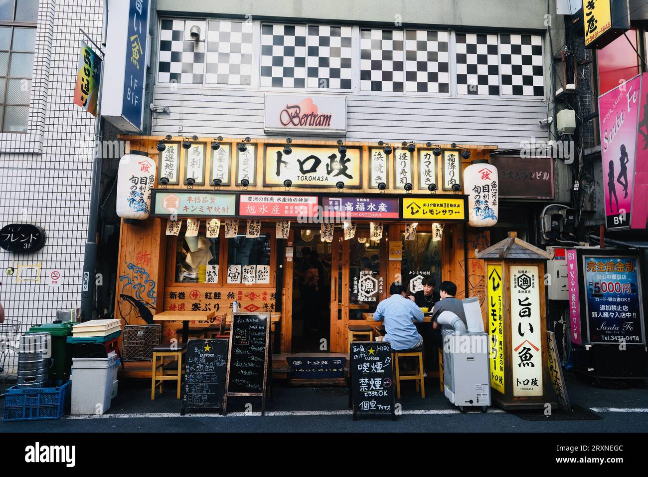 Gli uomini mangiano fuori da un ristorante a Shimbashi, Tokyo, Giappone Foto Stock