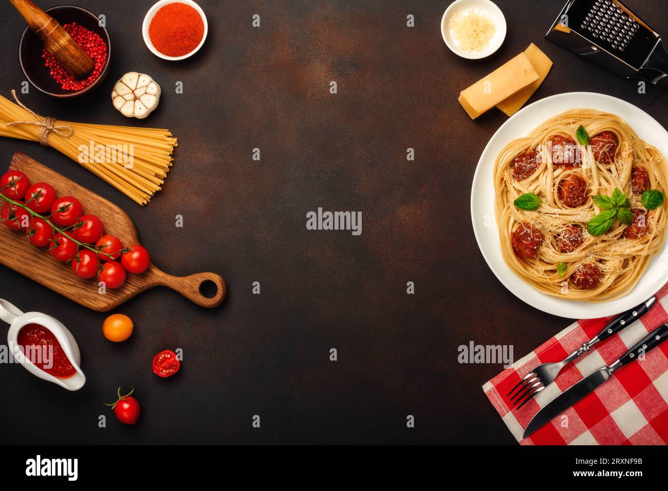Spaghetti con polpette, salsa di pomodoro ciliegia e formaggio su sfondo arrugginito, vista dall'alto. Foto Stock